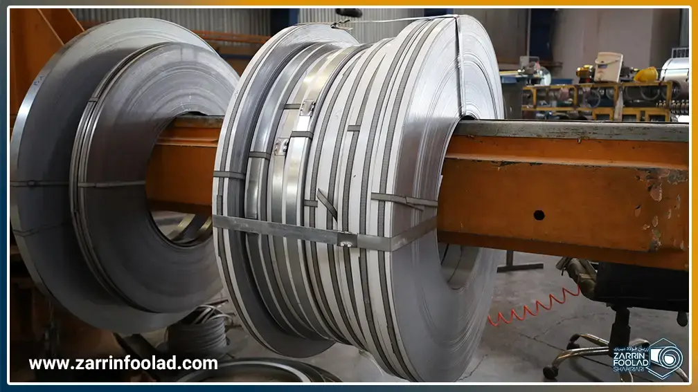 رول های گالوانیزه نواربری شده که بر روی کویل گیر النگویی قرار دارند.